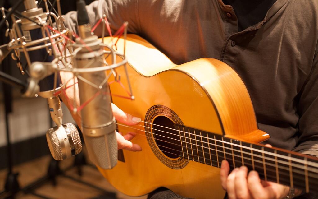 One of our music production course students recording a guitar