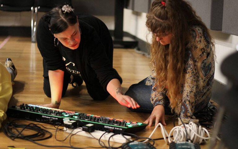 Students learning how to use a Roland sequencer for DJing