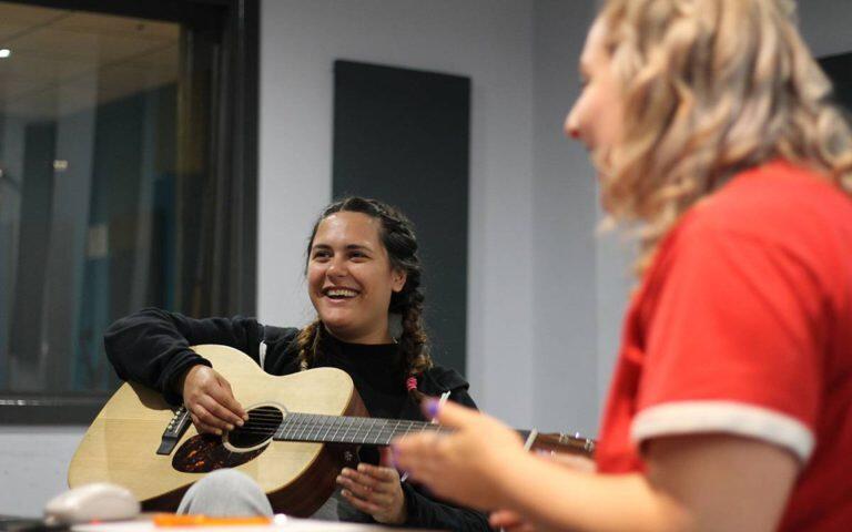 Students being happy with an acoustic guitar