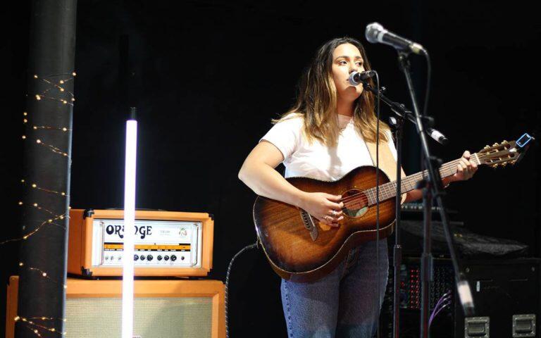 Student giving an acoustic performance after Kels Brooks workshop infront of Orange amplifiers.