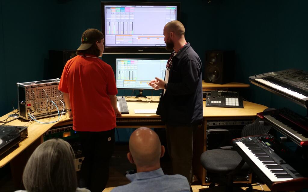 Dan Valentine showing a student how to use the synth suite at the open day